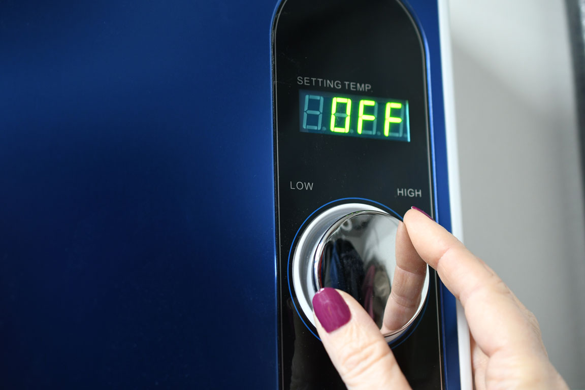 female hand adjusting water heater