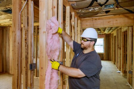 Construction worker installing insulation