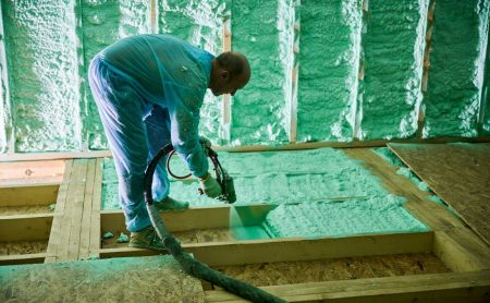 Worker spraying insulating foam